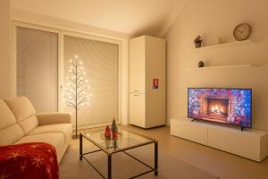 een woonkamer met een bank en een tv bij La Serena del Garda! in Desenzano del Garda