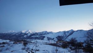 vistas a una cordillera nevada con montañas cubiertas de nieve en Hotel Qumli Apartment with mountain views, en Kʼumlistsʼikhe 2 fotos más