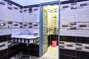 Un baño con lavabo y ducha en شاليه سيوة - Chalet Siwa, en Siwa