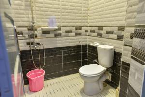 Un baño con inodoro y un cubo rosa. en شاليه سيوة - Chalet Siwa, en Siwa 20 fotos más