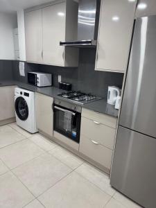 a kitchen with a stove and a refrigerator at East Croydon Comfort Apartments in Croydon