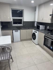 a kitchen with a washing machine and a dishwasher at East Croydon Comfort Apartments in Croydon +9 photos
