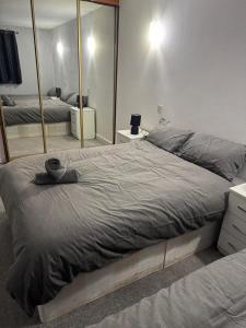 a bedroom with a large bed and a mirror at East Croydon Comfort Apartments in Croydon
