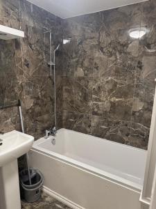 a bathroom with a bath tub and a sink at East Croydon Comfort Apartments in Croydon