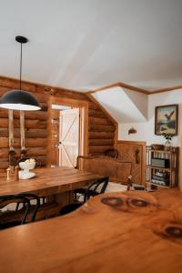 a dining room with a wooden table and chairs at Boutique Log Cabin & Two Guest Cabins, Hot Tub, Sauna, Swimming Hole, near Whiteface in Upper Jay
