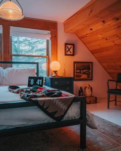 a bedroom with a bed in a room with wooden ceilings at Boutique Log Cabin & Two Guest Cabins, Hot Tub, Sauna, Swimming Hole, near Whiteface in Upper Jay +70 photos
