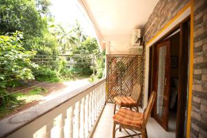 2 sillas sentadas en un balcón con ventana en Amber Studio, en Canacona 6 fotos más