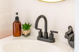 um balcão de cozinha com pia, dispensador de sabão e torneira em Short North Convention King Bed Free Parking! em Columbus