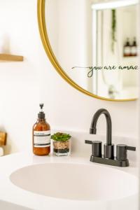 um lavatório de casa de banho com um espelho e um dispensador de sabão em Short North Convention King Bed Free Parking! em Columbus mais 70 fotografias