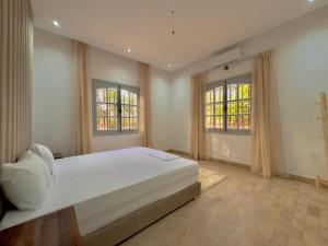 马拉喀什Charmante villa avec piscine privée et jardin的一间带一张大床和两扇窗户的卧室 更多48张照片