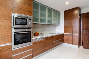 a kitchen with stainless steel appliances and wooden cabinets at Modern & Spacious Flat with Garage by HostWise in Vila Nova de Gaia