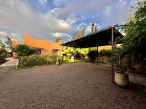 马拉喀什Charmante villa avec piscine privée et jardin的楼房前的亭子