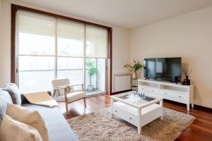 a living room with a couch and a tv at Modern & Spacious Flat with Garage by HostWise in Vila Nova de Gaia