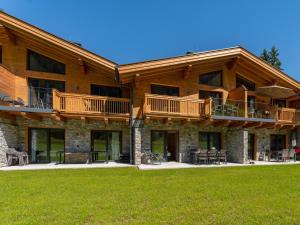 Casa de madera grande con terraza y césped en Tauernlodge Eben C4, en Gasthof