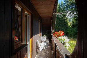 eine Veranda eines Hauses mit einer Bank und Blumen in der Unterkunft APARTMENT CHALET -BOHINJ- Pokljuka- Triglav National Park in Koprivnik v Bohinju