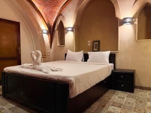 a bedroom with a large bed with towels on it at Saray El Omda - Wellness & Retreat Village in Luxor