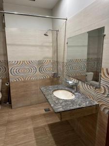 un baño con lavabo y espejo en Ilva Hotel, en Lahore