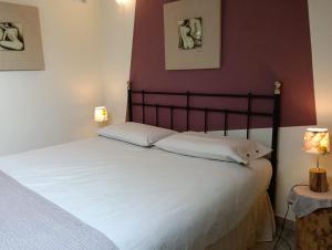 a bed with two white pillows in a bedroom at Casa Arcobaleno apartments-Room holiday home in Diano dʼAlba