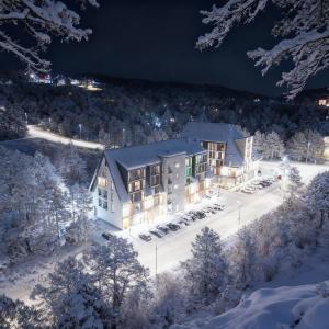 an aerial view of a building in the snow at night at Zlatni apartman Borovi in Divčibare +23 photos