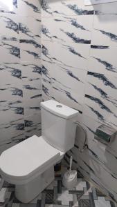 Berber Family的浴室铺有黑白瓷砖,设有白色卫生间。