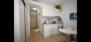 una piccola cucina con armadi bianchi e lavandino di Сарафово Дом a Burgas