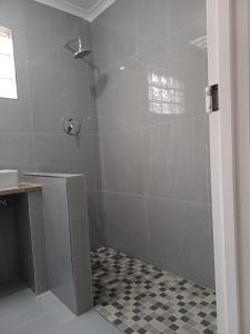 a bathroom with a shower with a glass door at Halaal Serenity 3bedroom 6sleeper in Cape Town