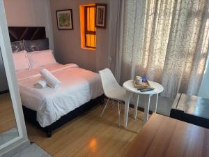 a small bedroom with a bed and a table at The Elegant Retreat of The Silver Room in Johannesburg