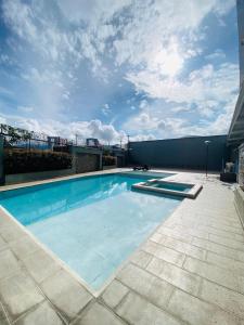 La vida es bella! hermoso apartamento con piscina cerca al centro de pereira في Dosquebradas: حمام سباحة كبير أعلى مبنى