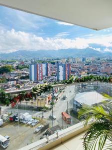 La vida es bella! hermoso apartamento con piscina cerca al centro de pereira في Dosquebradas: اطلاله على مدينه مع موقف سيارات