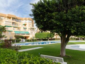 un albero di fronte a un edificio con piscina di Ap mayorazgo ii a Salobreña