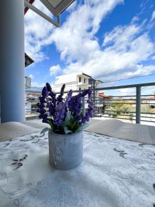 a vase filled with purple flowers on a table at Elenis House in Leptokaria