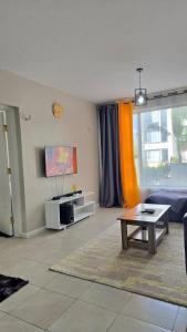 un soggiorno con un divano e un tavolo di Legatus Cozy Homes Ongata Rongai 3 bedroom a Ongata Rongai 