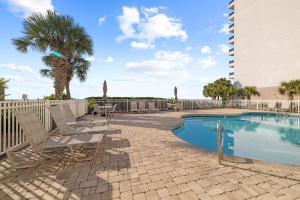 Una piscina con tumbonas al lado de un edificio. en Marlin Key 3E, en Orange Beach