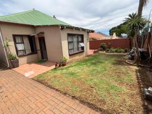 a house with a yard with a brick driveway at The Elegant Retreat of The Silver Room in Johannesburg