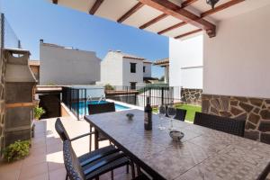 Casa lorenzo في Nigüelas: فناء مع طاولة وكراسي وحمام سباحة
