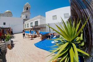 um grupo de pessoas sentadas em um pátio com uma planta em Casa Caracol em Cádis