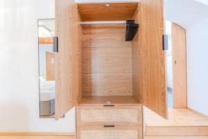 Cette chambre comprend un placard en bois avec un miroir. dans l'établissement Whats-App Self-Check-IN - Bad Aussee City House, à Bad Aussee