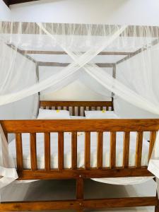 a bedroom with a wooden bed with mosquito nets at Villa Cinnaro in Ahangama