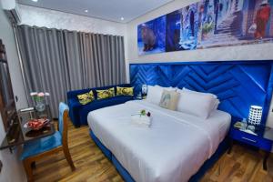 Hotel Dar Annasr في شفشاون: غرفة نوم بسرير ازرق وبيض واريكة