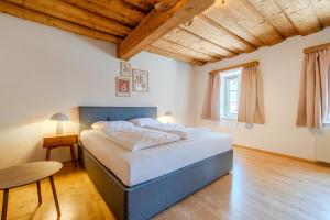 une chambre avec un grand lit dans une pièce avec des plafonds en bois dans l'établissement Whats-App Self-Check-IN - Bad Aussee City House, à Bad Aussee