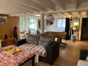 een woonkamer met een bank en een tafel bij Belle suite Un petit voyage au calme à 10 mnCV de Béziers entrée indépendante in Béziers