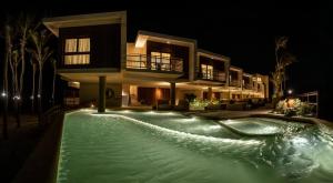 a house with a swimming pool at night at Lahaina Hotel in Icaraí