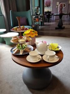 a table with plates of food and tea cups on it at The Chapter Hotels -Lancaster Gate in London +12 photos