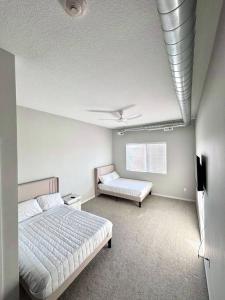 Casa Marigold في دي موين: غرفة نوم بها سريرين ومروحة سقف