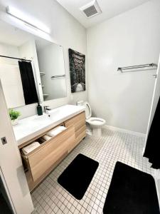 a bathroom with a sink and a toilet and a mirror at Monochrome Den in Des Moines +38 photos