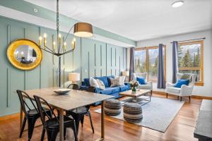 坎莫尔Luxurious Condo Mountain Views Hot-tub and Billiards的客厅里有一张桌子和一张蓝色沙发