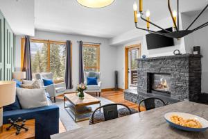 坎莫尔Luxurious Condo Mountain Views Hot-tub and Billiards的带蓝色沙发和壁炉的客厅