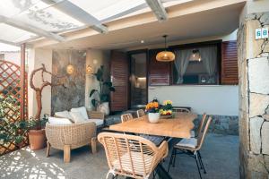 a patio with a wooden table and chairs at Dimora Su Tramonti a due passi dal mare! in Is Traias