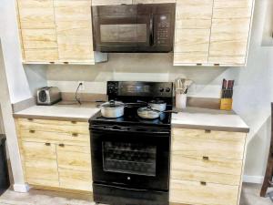 a kitchen with a black stove and a microwave at Indigo Studio in Des Moines
