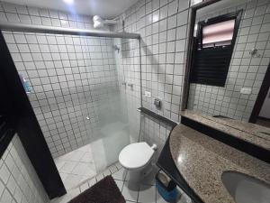 a bathroom with a toilet and a sink and a mirror at Carnatal Agora- 30m da Arena das Dunnas in Natal